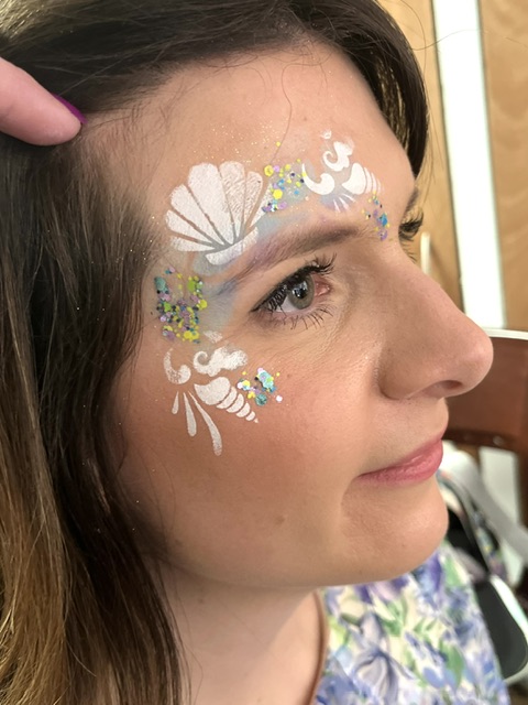 lady with her face painted with a mermaid design in Shifnal